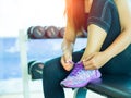 Closeup of woman tying shoe laces. Female sport fitness runner getting ready for jogging in gym room Royalty Free Stock Photo