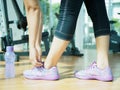 Closeup of woman tying shoe laces. Female sport fitness runner getting ready for jogging in gym room Royalty Free Stock Photo