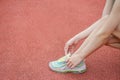 Running shoes - closeup of woman tying shoe laces. Female sport fitness runner getting ready for jogging outdoors on the lanes of Royalty Free Stock Photo