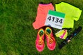 Running shoes, marathon race bib (number), runners gear and energy gels on grass background Royalty Free Stock Photo