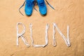 Running shoes and run sign made of shoelaces, sand Royalty Free Stock Photo