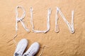 Running shoes and run sign made of shoelaces, sand Royalty Free Stock Photo