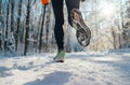 Running shoes sole close up image of winter jogger feet in running sneakers on the snowy park path during sunny day. Rear view Royalty Free Stock Photo