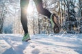 Running shoes sole close up image of winter jogger feet in running sneakers on the snowy park path during sunny day. Rear view Royalty Free Stock Photo