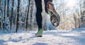 Running shoes sole close up image of winter jogger feet in running sneakers on the snowy park path during sunny day. Rear view Royalty Free Stock Photo