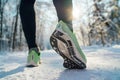 Running shoes sole close up image of winter jogger feet in running sneakers starting running on the snowy park path during sunny Royalty Free Stock Photo