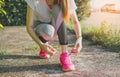 Running shoes - woman tying shoe laces. Female sport fitness runner getting ready for jogging outdoors on forest path in spring or Royalty Free Stock Photo