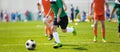 Running Soccer Football Players. Footballers Kicking Football Match; Young Soccer Players Running the Ball