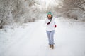 Running sport woman. Female runner jogging in cold winter forest wearing warm sporty running clothing and gloves Royalty Free Stock Photo