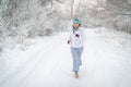 Running sport woman. Female runner jogging in cold winter forest wearing warm sporty running clothing and gloves Royalty Free Stock Photo