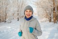 Running sport woman. Female runner jogging in cold winter forest wearing warm sporty running clothing and gloves Royalty Free Stock Photo