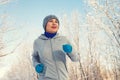 Running sport woman. Female runner jogging in cold winter forest wearing warm sporty running clothing and gloves Royalty Free Stock Photo