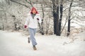 Running sport woman. Female runner jogging in cold winter forest wearing warm sporty running clothing and gloves Royalty Free Stock Photo