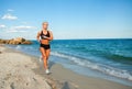 Running woman. Female runner jogging during outdoor workout on beach Royalty Free Stock Photo