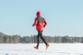 Running sportsman in protective sportswear making winter training session outdoors