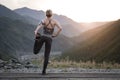 Running stretching. Athlete at the top of the mountain.