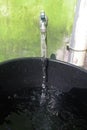 running tap water is accommodated with a black bucket container