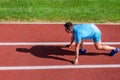 Running tips for beginners. Man athlete stand low start position at stadium path. Beginning of new lifestyle habit