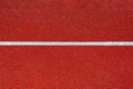 Running track texture.photo of the treadmill cover part in red color.red the texture of the track.White horizontal line on red bac