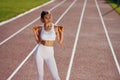 On the running track. Young woman in sportive clothes is exercising outdoors Royalty Free Stock Photo