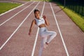 On the running track. Young woman in sportive clothes is exercising outdoors Royalty Free Stock Photo