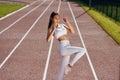 On the running track. Young woman in sportive clothes is exercising outdoors Royalty Free Stock Photo