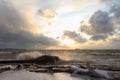 The running waves on the sandy snow-covered coast on a reservoir