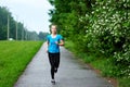 Running woman atletic spotsman training in the summer park. Outdoor fitness portrait