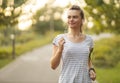 Running woman at the park in autumn season - Girl Runner Jogging Outdoor Workout - Young Female listening to music while jogging Royalty Free Stock Photo