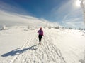 Running woman on winter trail, snow and white mountains