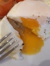 Runny egg and a fork up close