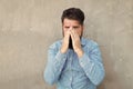 Runny nose. Man bearded hipster with sneezing face closed eyes close up concrete wall background. Brutal hipster Royalty Free Stock Photo