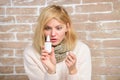 Runny nose and other symptoms of cold. Nasal spray runny nose remedy. Girl sick person hold nasal drops and tissue Royalty Free Stock Photo