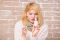 Runny nose and other symptoms of cold. Nasal spray runny nose remedy. Girl sick person hold nasal drops and tissue Royalty Free Stock Photo