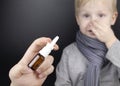 A runny nose is treated with a medicine from a nasal spray. Nasal drops on a black background. Concept for treating a baby cold or