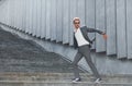 Runs and lating to the job. Young businessman in grey formal wear is outdoors in the city Royalty Free Stock Photo