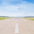 Runway at the airport in sunny summer noon with clouds