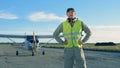 Runway with pilot standing near airplane and removing earphones. 4K.