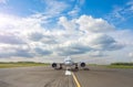 Runway with passenger airplane ready for take off, airstrip with marking on blue sky with clouds background. Travel aviation Royalty Free Stock Photo