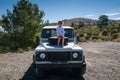 Rural Andalucia. Spain. 06/10/2016. Little girl admiring views while sitting on front spare tyre on a bonnet hood in 4x4 terrain.