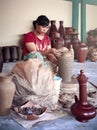 Rural asian potter master woman molds from clay pot in master. Ceramic handmade craft. Pottery