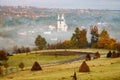 rural autumn landscape with fog and hay stacks Royalty Free Stock Photo