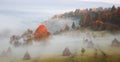 rural autumn landscape with fog and hay stacks Royalty Free Stock Photo