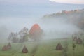 rural autumn landscape with fog and hay stacks Royalty Free Stock Photo