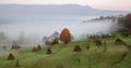 rural autumn landscape with fog and hay stacks Royalty Free Stock Photo