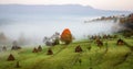 rural autumn landscape with fog and hay stacks Royalty Free Stock Photo