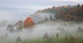 rural autumn landscape with fog and hay stacks Royalty Free Stock Photo