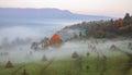 rural autumn landscape with fog and hay stacks Royalty Free Stock Photo