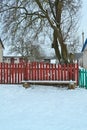 Rural bench with colorful fence in winter day. Countryside landscape. Travel concept. Relax nature concept. Russian village street Royalty Free Stock Photo