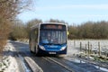 Rural bus service in winter on slippy road.